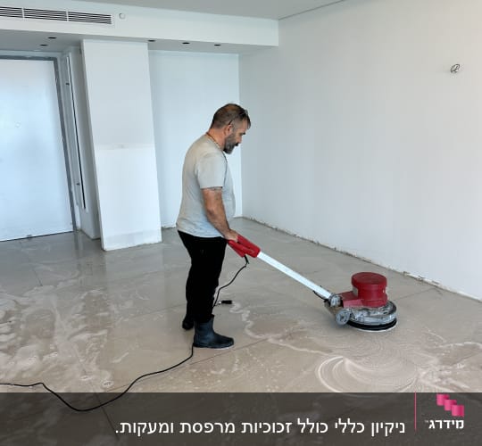 אדם מנקה רצפה עם מכונת פוליש אדומה